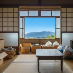 徳島での解体費用を安くするためにまとめられた、日本家屋室内の残置物(段ボールや袋)。窓からは徳島の山並みと青空が見える。