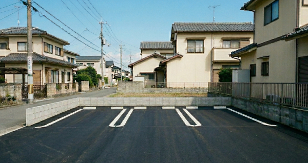 徳島県徳島市の住宅街にある駐車場舗装の施工事例。アスファルト舗装と、車両同士の間隔を広く確保できる最新のU字型白線。