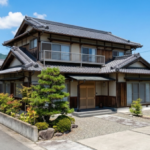 青空の下、徳島でよく見られる伝統的な瓦屋根と手入れされた庭を持つ、立派な木造二階建て住宅