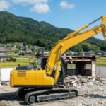 徳島の解体現場で稼働する、低騒音・低振動のコンクリート圧砕機付き黄色油圧ショベル（ご近所トラブル対策）