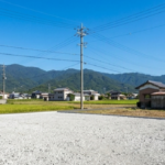 徳島での古い小屋解体のビフォーアフター比較。老朽化した物置を撤去し、青空の下できれいな砂利敷きの更地へ整地した様子。