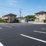 解体後アスファルトの舗装工事をして駐車場にした写真