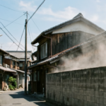 住宅街でブロック塀の解体工事中に発生する激しい粉塵と埃でトラブルが起こりそうな様子