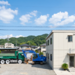 徳島の青空の下に佇む清潔感のある許可のある解体業者の事務所と重機・ダンプカーの風景