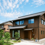 代替テキスト：青空の下に建つ徳島の典型的な木造2階建ての一軒家と周辺の住宅街