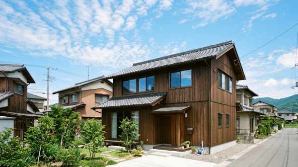 代替テキスト：青空の下に建つ徳島の典型的な木造2階建ての一軒家と周辺の住宅街
