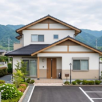 建物と駐車場のアスファルトが並ぶ、住宅の敷地全体を引いて撮った写真
