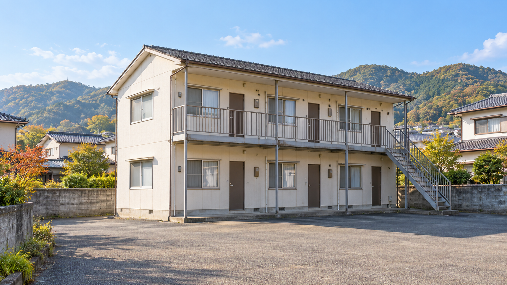 建物全体と外階段、駐輪場、重機の進入経路が分かる実際の現場写真